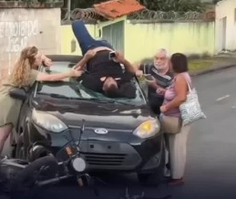 Motociclista ferido usa celular sobre capô enquanto espera socorro em BH; veja vídeo